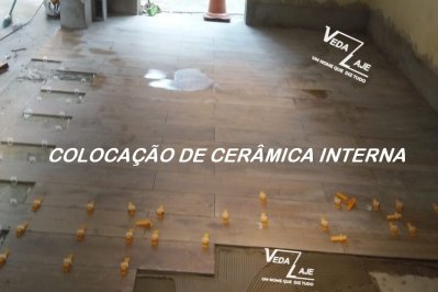 Colocação e nivelamento de porcelanato imitando madeira na área de entrada do salão de festas